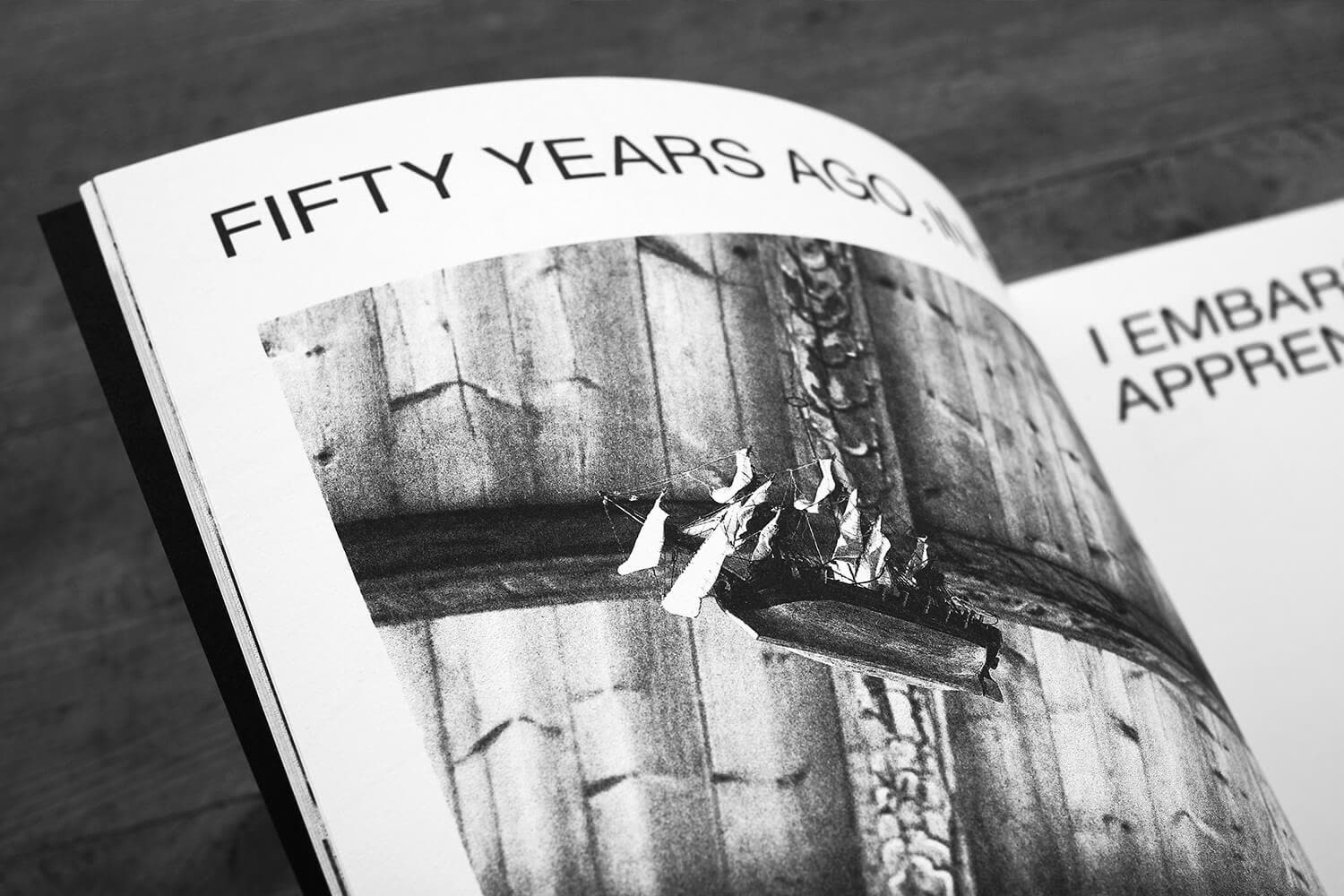 Spread opening with a line of type over a black and white photograph