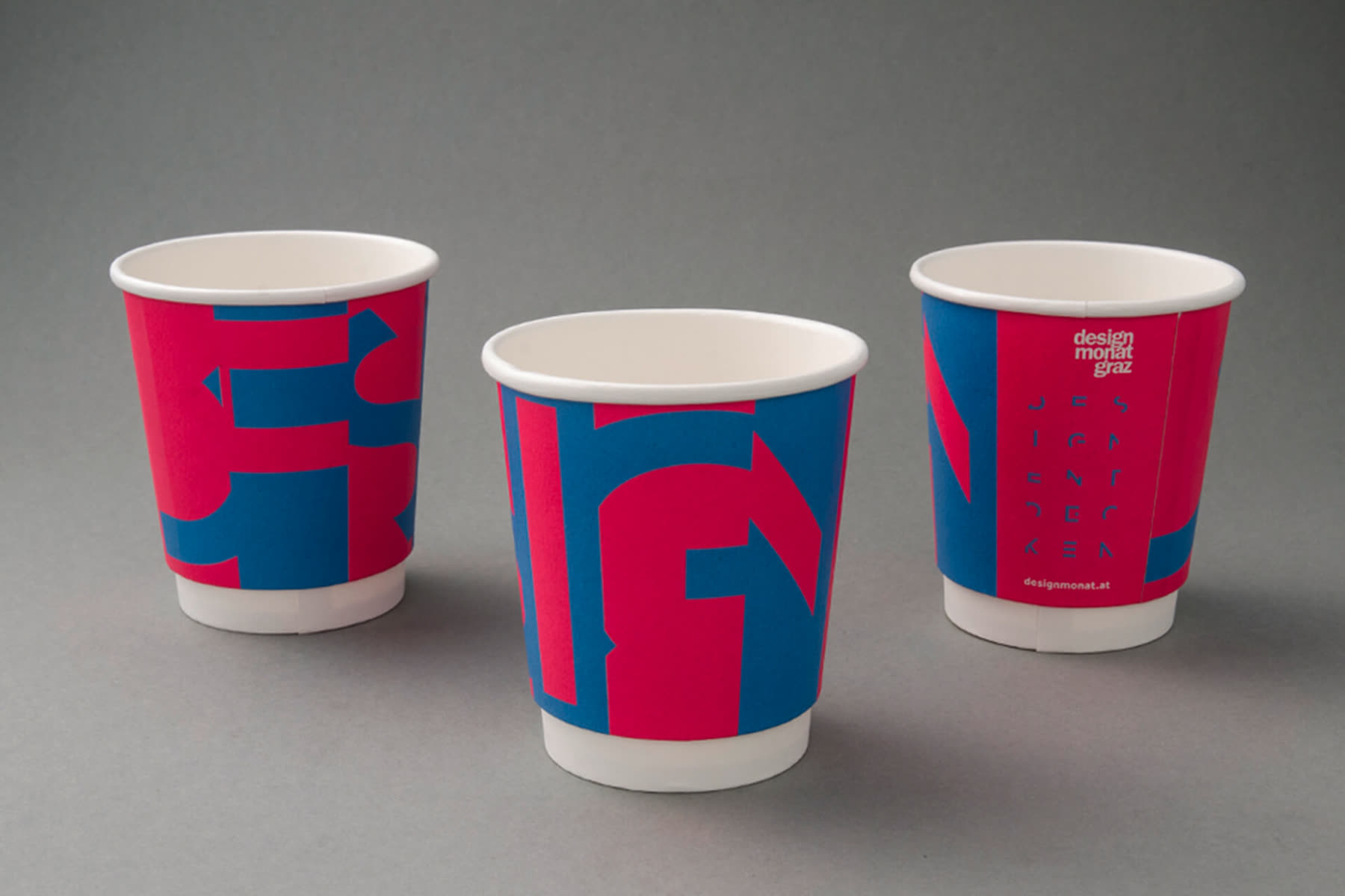 Three paper cups in pink and blue