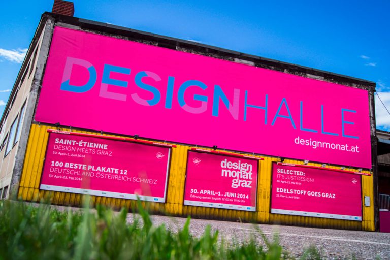 Pink billboard on a hall facade under blue sky