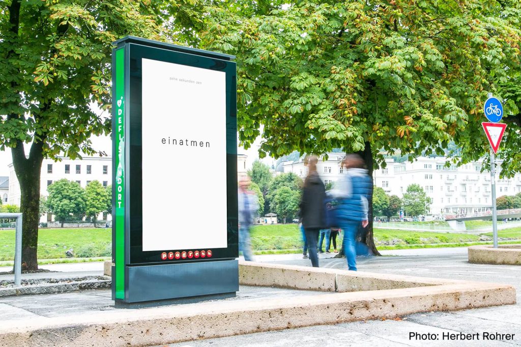 City Light screen in a park showing the single word einatmen
