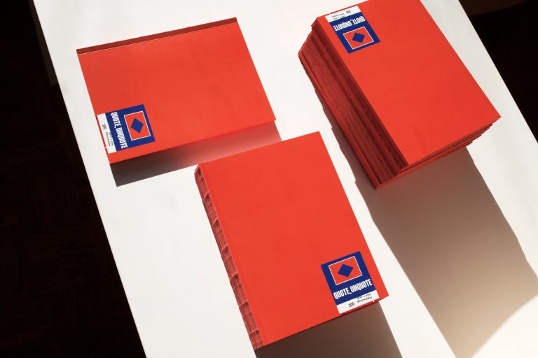 Three orange copies of QUOTE, UNQUOTE in hard sunlight
