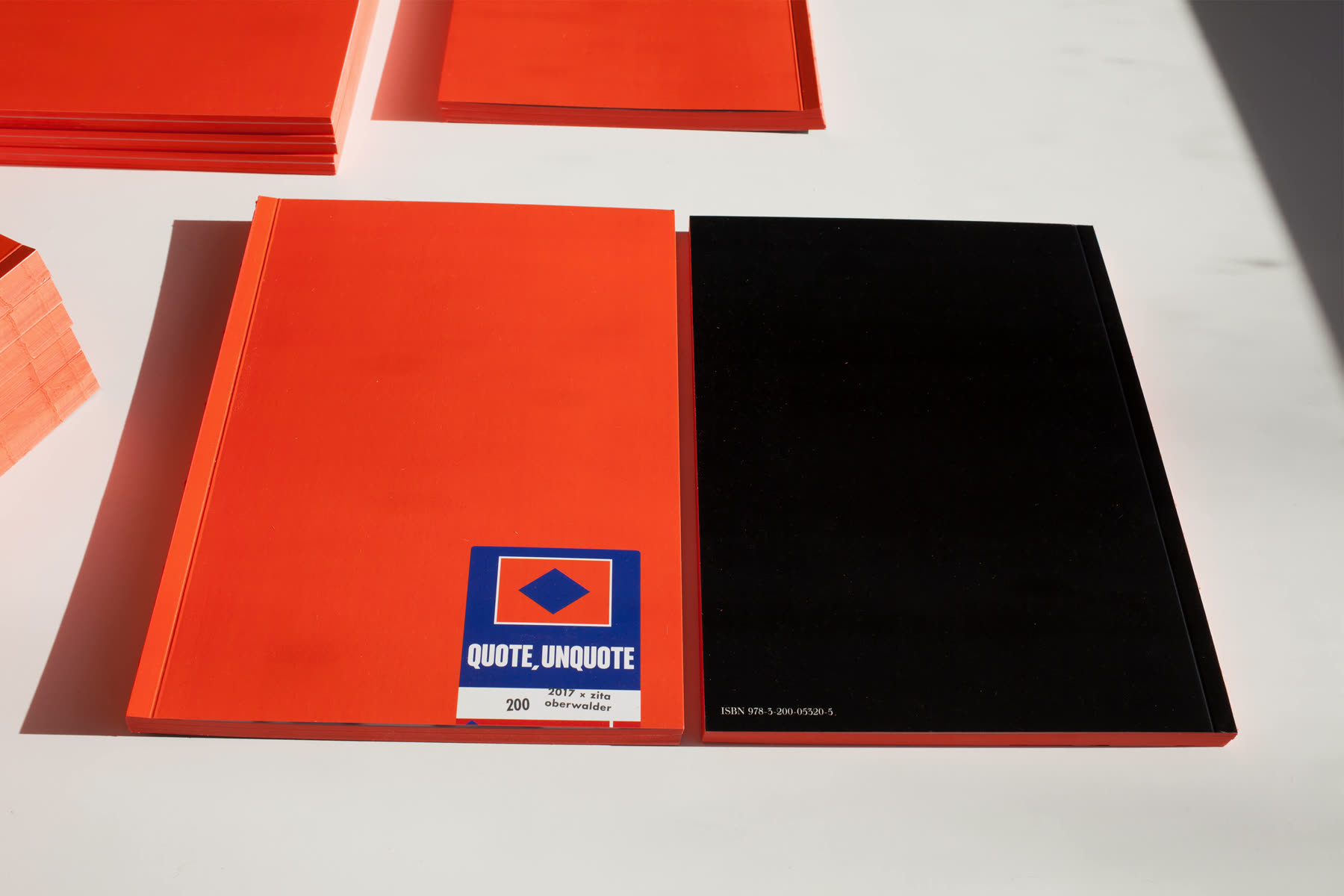 An orange and a black volume side by side