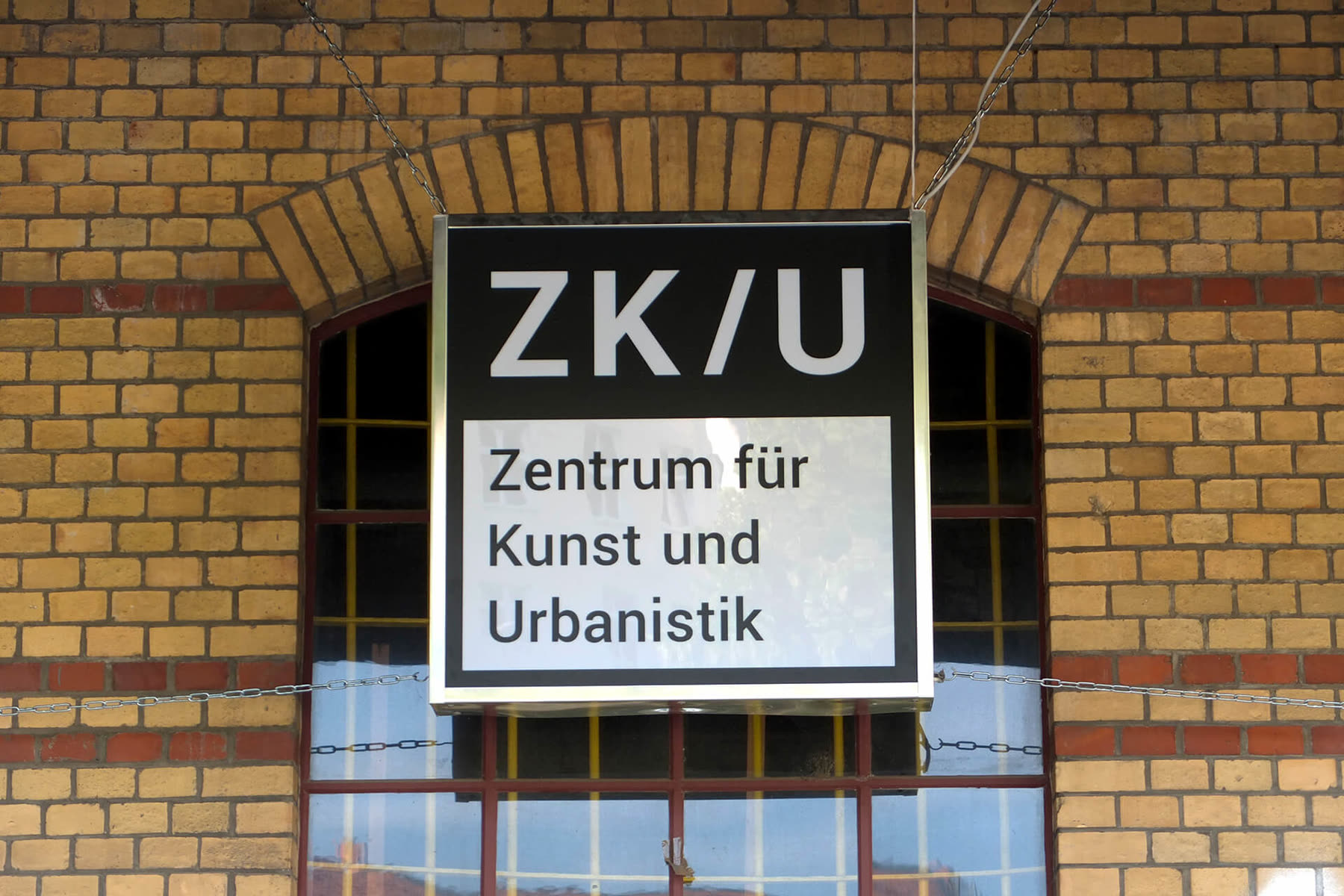 ZK/U sign hanging in an arched brick doorway